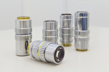 Detail of microscope lens on an white background.Closeup of microscope objectives.