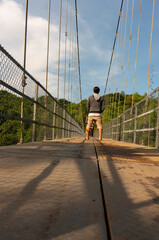 A man standing on a suspension bridge