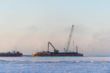  Barge with crane. Dredger working at sea. Sunset in Arctic sea. Construction Marine offshore works. Dam building, crane, barge, dredger.