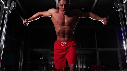 Gym training - adult fit man training his hands with an effort using exercise equipment