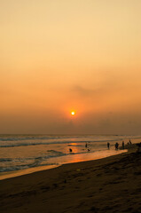 playa con personas atardecer en el mar