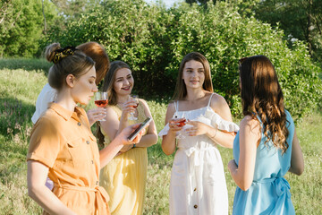 Summer Picnic Gatherings, Summer party time, summer drinks cocktails, Small gathering of friends. Young women girlfriends having fun together at picnic and holding glasses with alcohol drinks