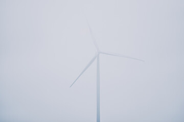 Closeup of a wind turbine in the morning fog
