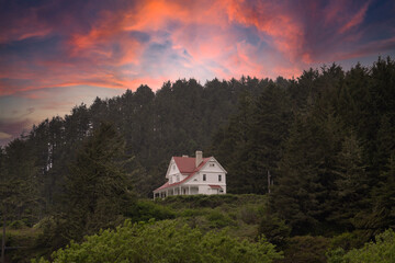 Historic lighthouse keepers house at sunsetat Heceta Head near Cape Perpetua on the Oregon coast near Floresnce.