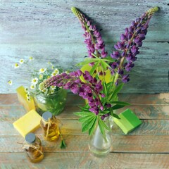 Bouquet of useful herbs and flowers, natural soap, aromatic oil on a wooden background