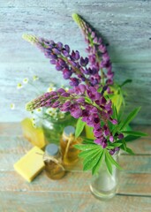 Bouquet of useful herbs and flowers, natural soap, aromatic oil on a wooden background