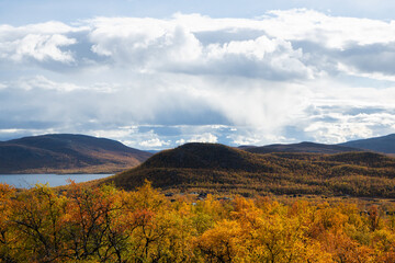 Amazing view of the Lake among colorful fall forest, Lapland. Scenic wooded mountains. Kilpisjarvi.