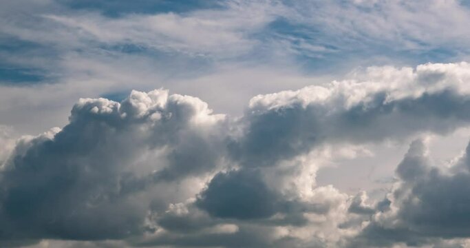 Time lapse clip of several fluffy curly rolling cloud layers in windy weather