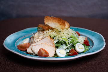 Greek salad with chicken breadcrumbs on a plate in a cafe.