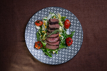 juicy slicing of grilled beef with vegetables kind of from top.