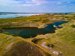 An aerial view of a tranquil pond found in a hidden valley in the vast Saskatchewan prairies