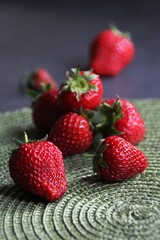 fresh strawberries, strawberries on a green pad, dark background, spring red fruits, strawberries with stalks