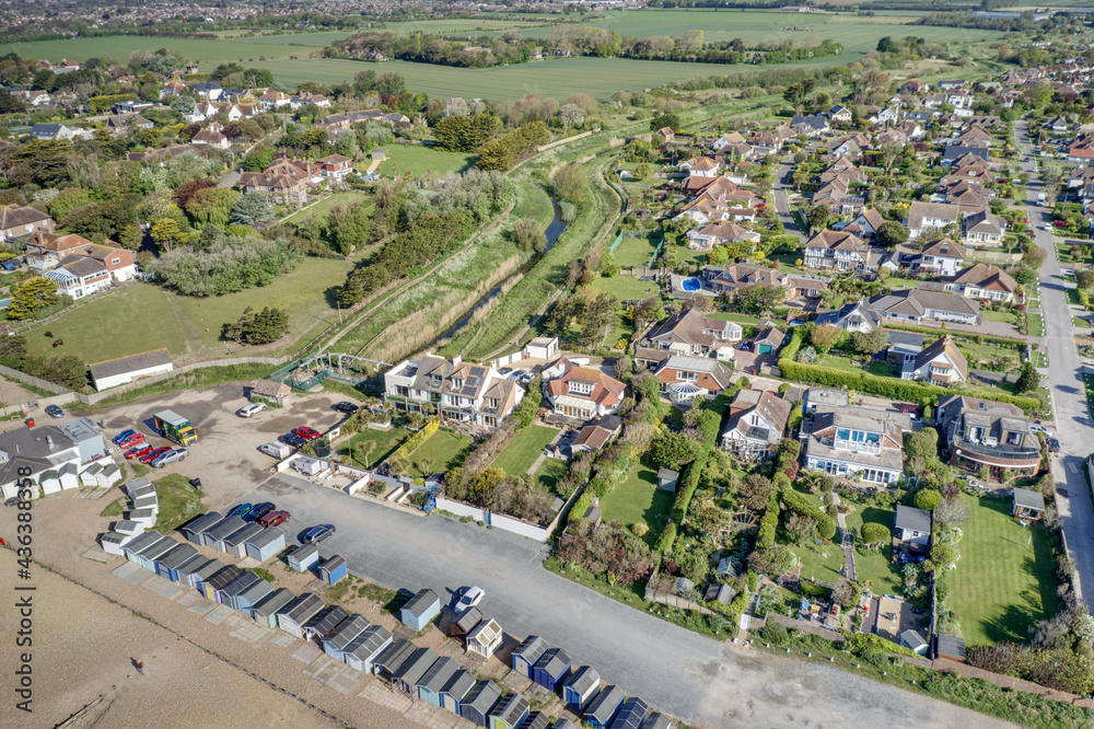 Wall mural Ferring seafront on the English Channel with the Aerial view of Ferring Rife running next to the village of Ferring in West Sussex and towards the Beach Huts and coastline. - Wall murals