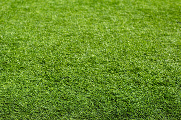 The texture of bright artificial green grass. Football field.