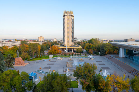 Kazakhstan Hotel tower in Abai Square, Almaty. Vegetation and water fountains in Abay Square in front of the Palace of the Republ