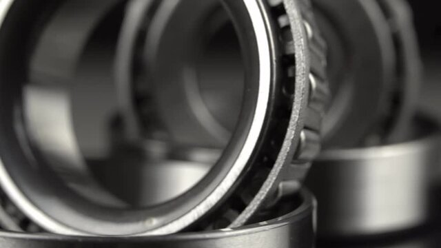 Cyclic seamless video with bearings rotating on a turntable on a black background. The two bearings rotate around their axis. Mechanism concept and equipment. Close-up, macro.