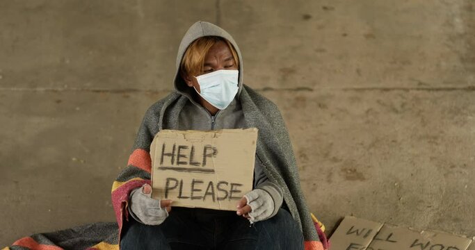 Homeless man holding help please label