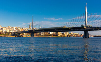 Fototapeta na wymiar View of Golden Horn bay with cable-stayed metro bridge connecting Beyoglu and Fatih districts on sunny winter day, Istanbul, Turkey