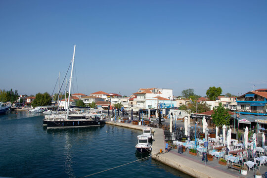 Boats at the port of village of Keramoti, Greece. Thasos island harbor, beautiful blue water and sky, tavernas, caf&eacute; and restaurants, travel destination