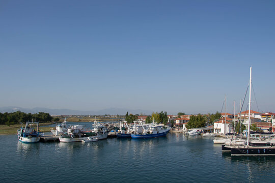 Boats at the port of village of Keramoti, Greece. Thasos island harbor, beautiful blue water and sky, tavernas, caf&eacute; and restaurants, travel destination