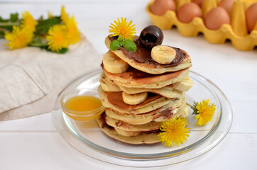 stack of pancakes with chocolate and banana and spring flowers