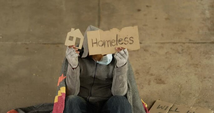 Homeless man holding home and homeless label