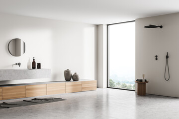 Light bathroom interior with shower, sink with mirror near panoramic window