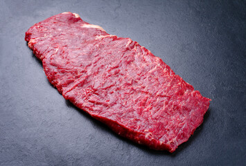 Raw wagyu skirt beef steak offered as close-up on a black board with copy space