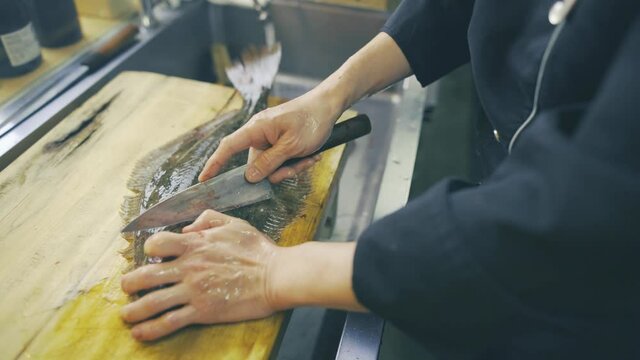 料理人が魚を捌く