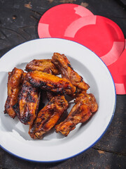 Fried chicken wings on enamel plate. black wooden background