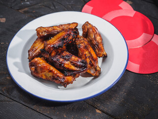 Fried chicken wings on enamel plate. black wooden background