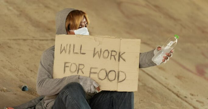 Homeless man holding will work for food label