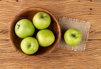 Green apples in a bowl over wooden table