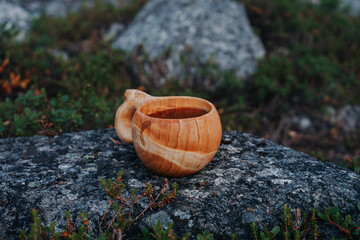 Traditional wooden Sami Cup (kuksa)  on stone in the tundra, Kola Peninsula 