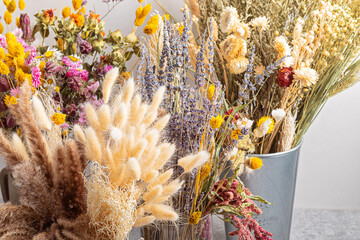 Bouquets of dry flowers and herbs, trendy interior decoration, artisan florist shop idea.