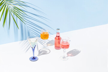 Creative summer composition with a fresh colorful cocktails, a glass and green palm branch. Summer, tropical, fresh cocktail concept.
