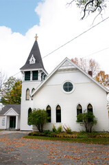 Fototapeta premium Clapboard church in New England in the USA.In New England the forests provide the materials for Clapboard houses, churches and covered bridges usually made from split oak, pine and spruce