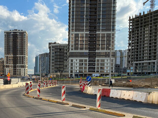 Repair and construction of a road with temporary road signs and cones against the background of...