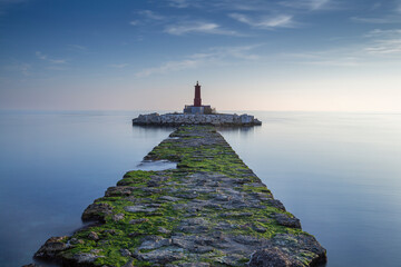 Lighthouse at the end of the pier in a sea of ​​silk in the coastal town of Villajollosa, Alicante Province, Spain © Jose