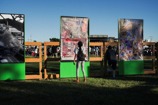 A young girl looks at the Greenwood Art Project during festivities of the 100 year anniversary of the 1921 Tulsa Massacre in Tulsa