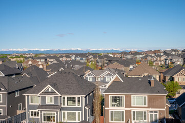 Roof top view of modern suburban home in Calgary with mountain in the background. 