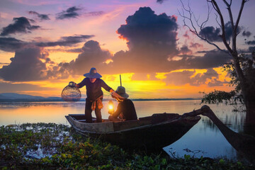 Naklejka na ściany i meble Fishermen fishing in the early morning golden light.