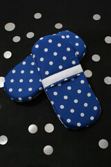 Pair of colored sneakers with white polka dots, with a black background. Slippers for walking at home. Rest concept.