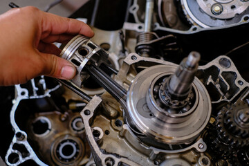 Maintenance and repair of motorcycle engine piston gear system.