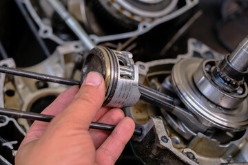 Maintenance and repair of motorcycle engine piston gear system.