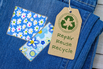Sustainable fashion label on repaired jeans, sustainable fashion visible mending concept, repair, reuse, recycle, clothes and textiles to reduce waste
