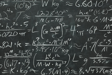 Math equations and formula written in chalk on messy chalkboard or blackboard background. School or...