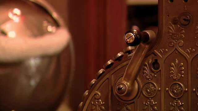 Man using an Antique Crank-operated Cash Register. Close Up.  