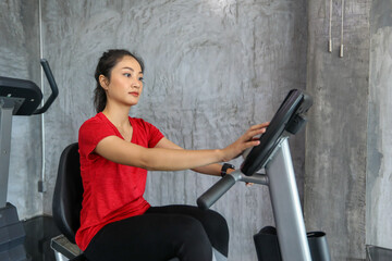 Fototapeta na wymiar Female on gym bike doing cardio exercise.