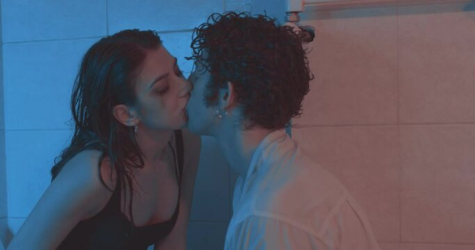 sex and drugs - stoned couple in the bathroom kisses and smokes a joint